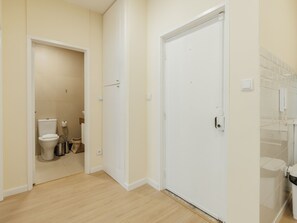 Ein helles, modernes Badezimmer mit Toilette, Waschbecken und Duschbereich.