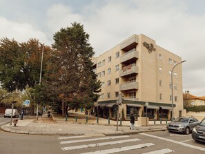 Monikerroksinen hotelli, jossa on katutasossa sijaitseva ravintola, jalankulkijoiden ylityspaikka ja pysäköintialue.