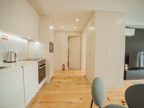 A modern kitchen with white cabinets, a stainless steel kettle, and a built-in oven. - Apartment  by Interhome (Porto)
