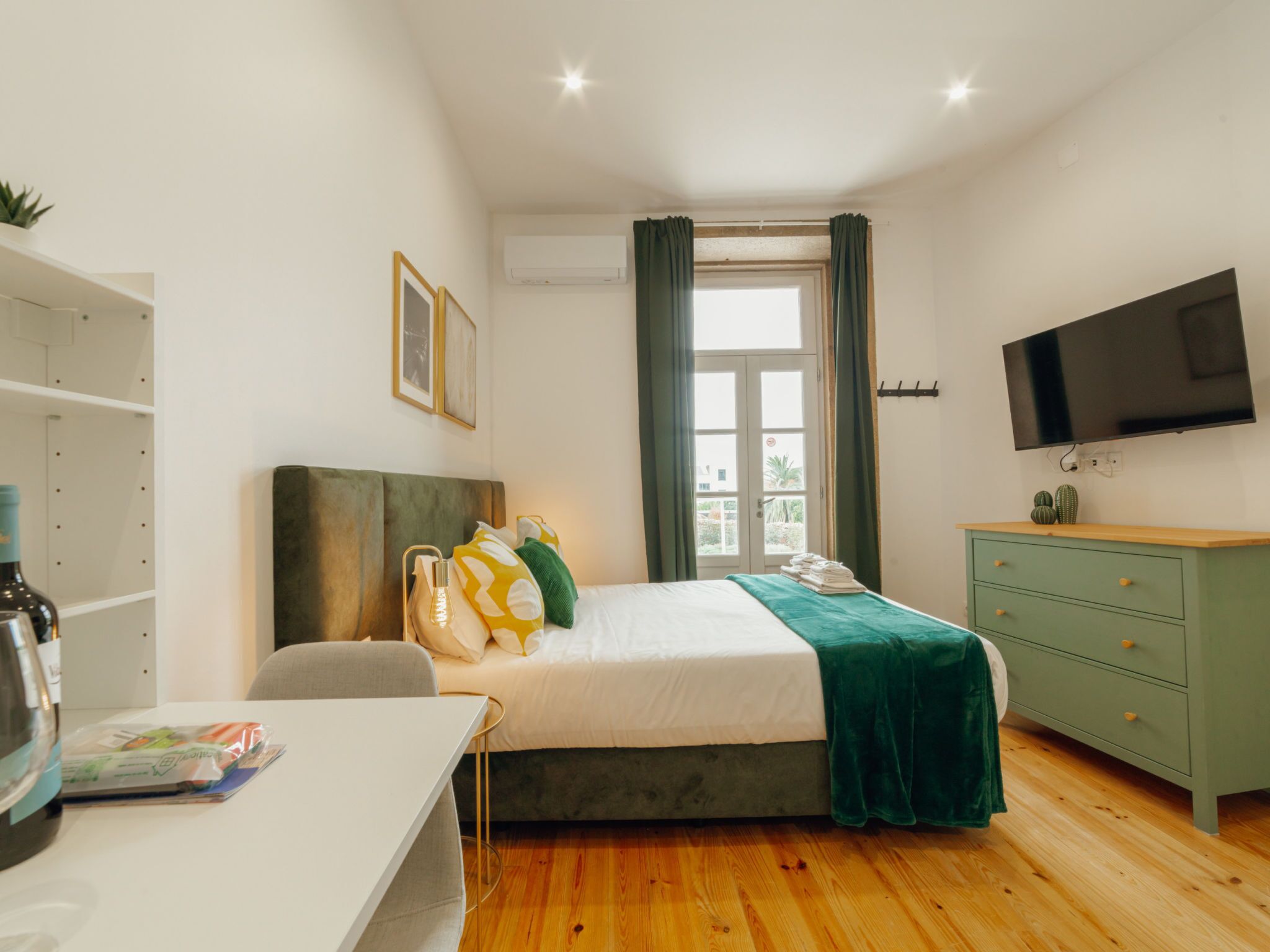 Ein Hotelzimmer mit Bett, Schreibtisch, Fernseher und Kleiderschrank.