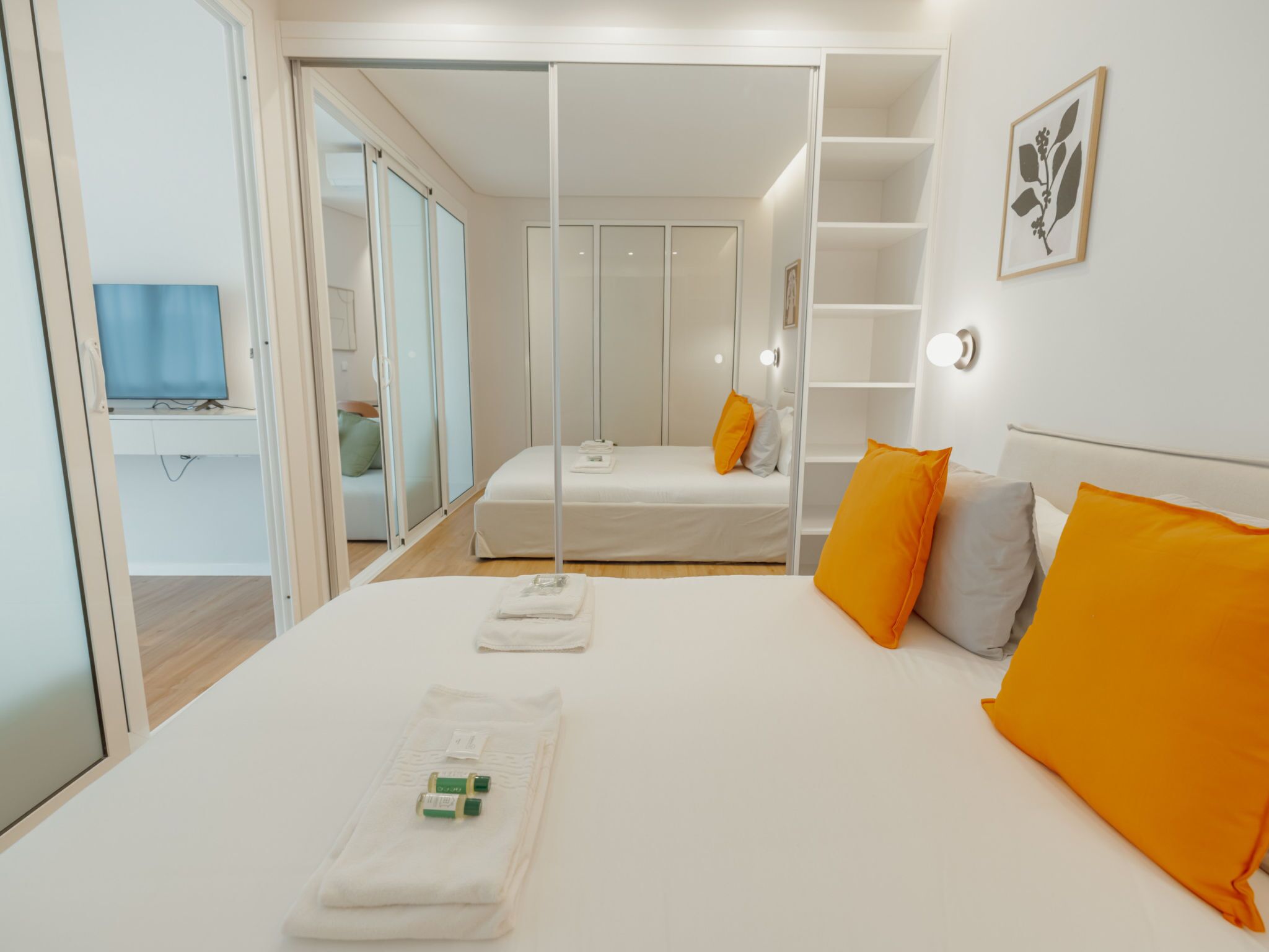 Ein Schlafzimmer mit Bett, Fernseher, Kleiderschrank und Nachttisch.
