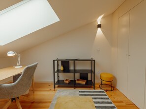 A room with a desk, chair, bookshelf, and a small stool. - Apartment  by Interhome (Porto)