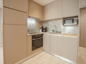 A modern kitchen with a built-in oven, microwave, and coffee maker. - Apartment  by Interhome (Porto)