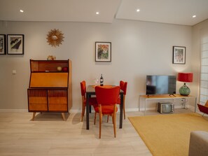 A modern living room with a dining area, a television, and a vintage radio. - Apartment  by Interhome (Porto)