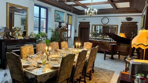 A dining room with a large table set for a meal, surrounded by chairs. - 18th century Castle of Clairefontaine (Garchizy)