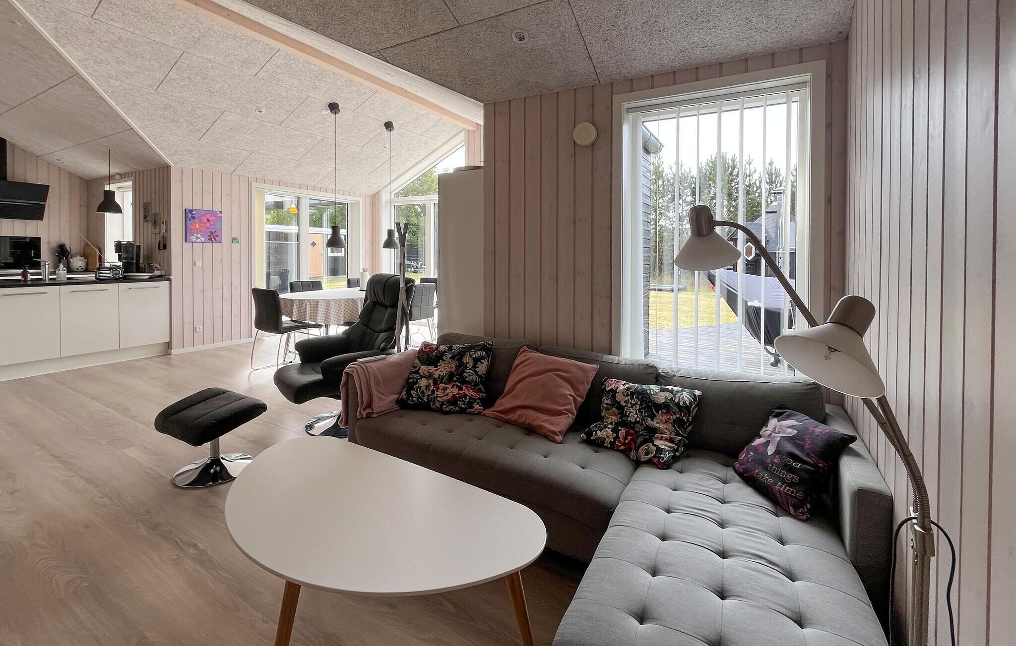 Ein modernes Wohnzimmer mit einer Couch, einem Couchtisch und einem Essbereich mit Stühlen und einem Tisch.