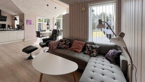 Una sala de estar moderna con un sofá, una mesa de centro y un comedor con sillas y una mesa.