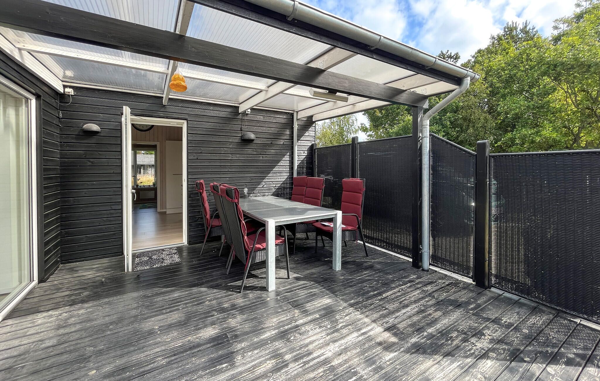 An outdoor patio with a table and chairs, a covered seating area, and a view of the surrounding greenery.