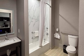 Een badkamer met bad, toilet en wastafel.
