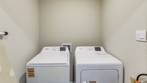 A laundry room with two front-loading Whirlpool washers and a wall-mounted dryer. - Family-Friendly Fort Worth Home: Private Yard (Fort Worth)