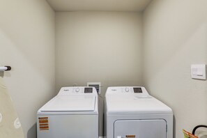 Ein Waschraum mit zwei Whirlpool Waschmaschinen mit Frontlader und einem an der Wand befestigten Trockner.
