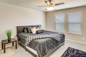A bedroom with a bed, bedside table, and a ceiling fan. - Family-Friendly Fort Worth Home: Private Yard (Fort Worth)