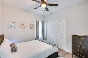 A bedroom with a bed, a ceiling fan, a dresser, and a door. - 3 Mi to Dtwn & EverBank Stadium! Family Townhome (Jacksonville)