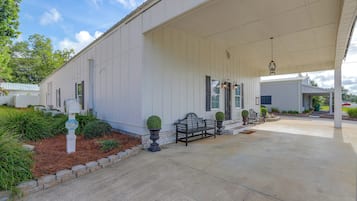 A covered porch with a bench, a mailbox, and a security camera.