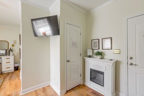 A room with a fireplace, a mounted television, and a door with a notice on it. - 1 Mi to Dtwn Sylvester: Studio w/ Shared Fire Pit! (Sylvester)