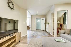 A living room with a flat-screen TV, a sofa, a coffee table, and a framed picture. - Updated Duplex - 3 Mi to Newark Penn Station! (Newark)