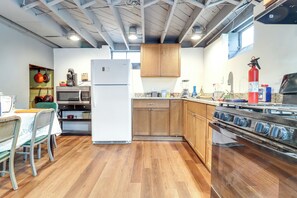 A compact kitchen with wooden cabinets, a refrigerator, a microwave, and a stove. - 8 Mi to Dtwn Detroit! Apt w/ Shared Yard (Dearborn)