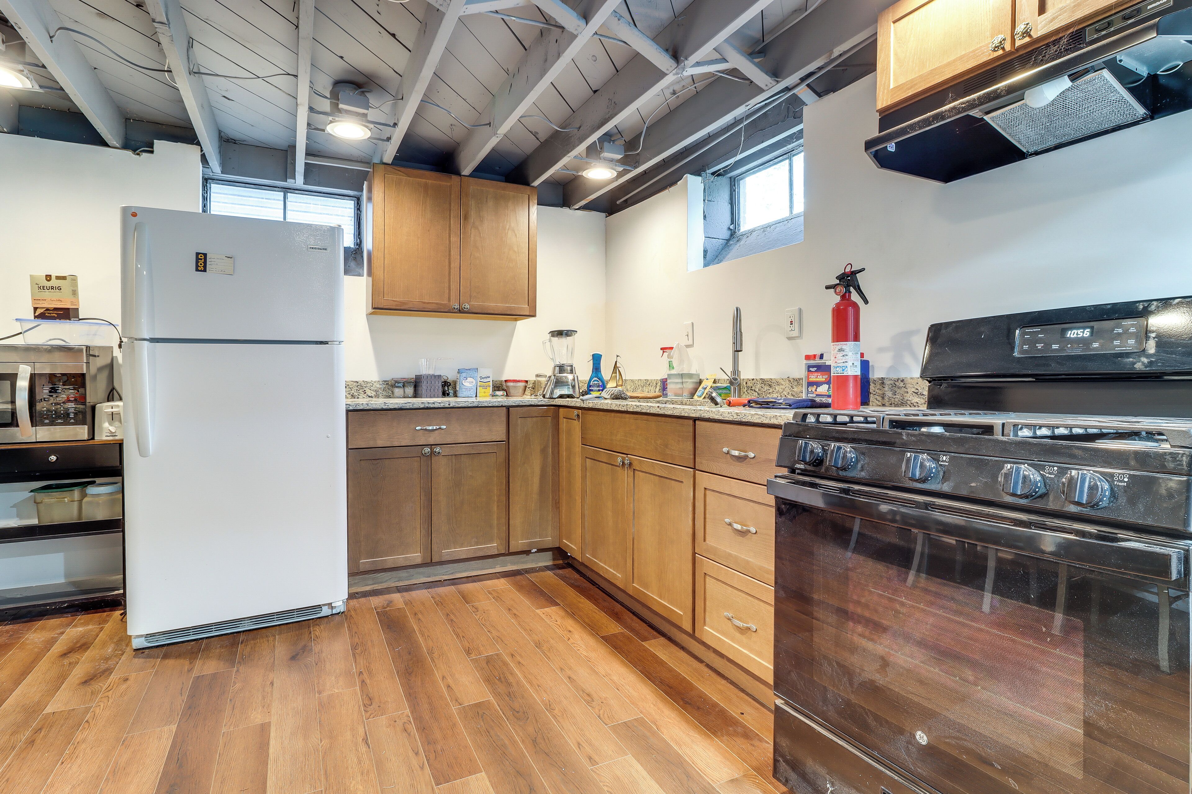 A kitchen with wooden cabinets, a white refrigerator, a stove, and a window.