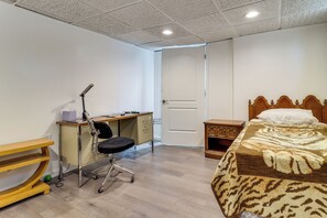A bedroom with a bed, desk, chair, and wardrobe. - 8 Mi to Dtwn Detroit! Apt w/ Shared Yard (Dearborn)
