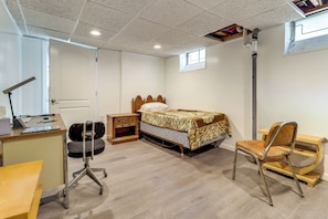 A bedroom with a bed, desk, chair, and a guitar case. - 8 Mi to Dtwn Detroit! Apt w/ Shared Yard (Dearborn)