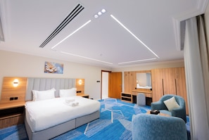 A modern hotel room with a large bed, a desk, a chair, and a bathroom. - Viola Al- Asalah (Dammam)
