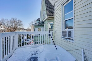 Ein Wohnhaus mit verschneiter Veranda und sichtbarer Klimaanlage.