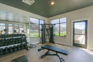 A gym with exercise equipment, a bench, and dumbbells. - Extended Stay In Fort Collins! Townhome w/ Gym (Fort Collins)