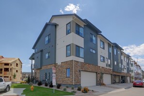 A multi-story residential building with a stone facade, a fire lane sign, and a private parking sign. - Extended Stay In Fort Collins! Townhome w/ Gym (Fort Collins)