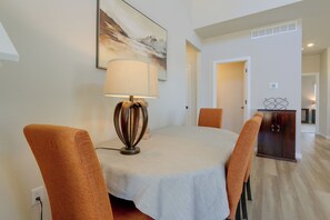 A dining area with a table, chairs, a lamp, and a painting on the wall. - Extended Stay In Fort Collins! Townhome w/ Gym (Fort Collins)