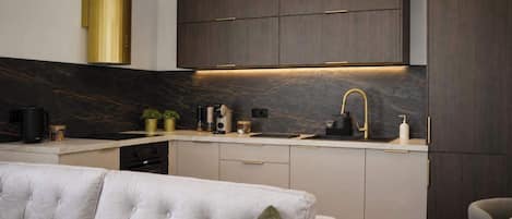 A modern kitchen with dark wood cabinets, a built-in oven, and a sleek countertop.