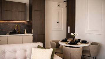 Un espace repas moderne avec une table ronde pour quatre personnes, un canapé et des meubles de rangement en bois foncé.