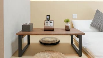 Un dormitorio ordenado con una cama, una mesita de noche y un cuadro en la pared.