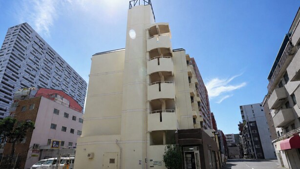 A multi-story building with a flat facade, a visible entrance, and a parking sign indicating a 24-hour parking area. - b&Tsutenkaku 4 (Naniwa Ward,Osaka)