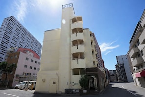 A multi-story building with a flat facade, a visible entrance, and a parking sign indicating a 24-hour parking area. - b&Tsutenkaku 4 (Naniwa Ward,Osaka)