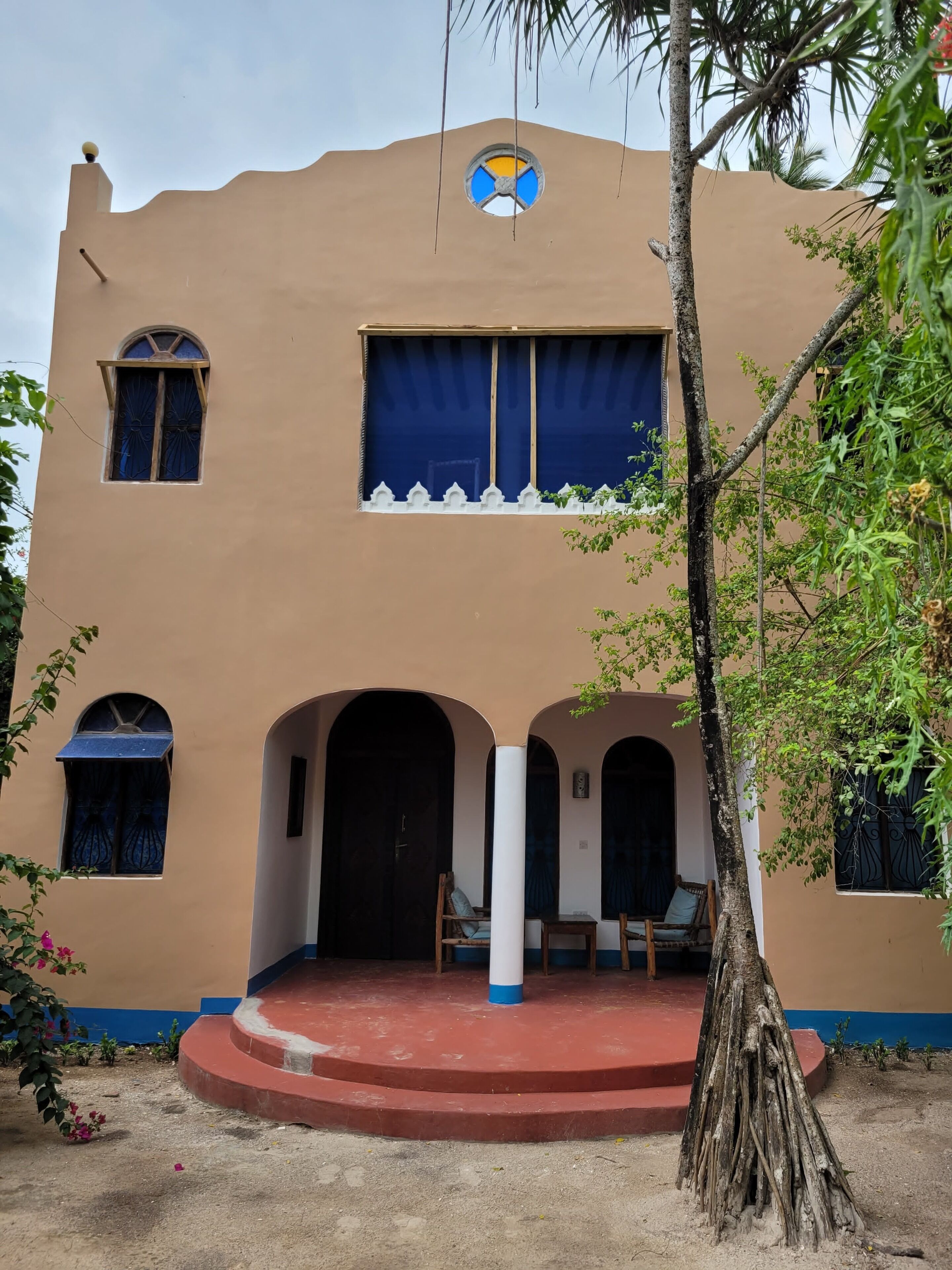 A building with a central courtyard, arched doorways, and a small seating area.
