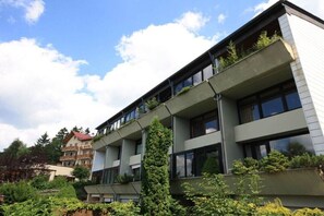 Ein mehrstöckiges Gebäude mit Balkonen, großen Fenstern und blauem Himmel.