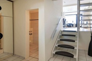 Eine Treppe mit Handlauf, die zu einem Raum mit Blick ins Freie führt.