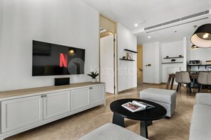 A modern living room with a flat-screen TV, a coffee table, and a seating area. - Karven by Kozystay - Cilandak (South Jakarta)