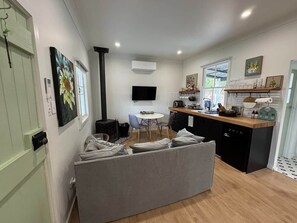 A compact living space with a sofa, a dining table, and a kitchenette area.