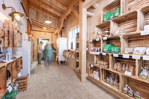 A wooden interior with shelves stocked with various food items and a refrigerator. - Chalet at the Zlaim lift with sauna (Grundlsee)