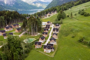 A cluster of wooden cabins with a lake and mountains in the background. - Chalet at the Zlaim lift with sauna (Grundlsee)