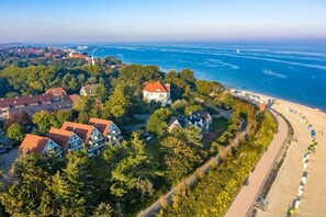 Ein Küstenwohngebiet mit Häusern, einem Strand und einem Leuchtturm.