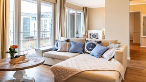 A modern living room with a sofa, a coffee table, and a view of the outside. - Bel blue, Residence Bel Vital (Binz)