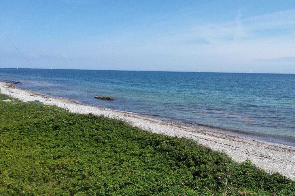 A beach with clear water and a sandy shore.