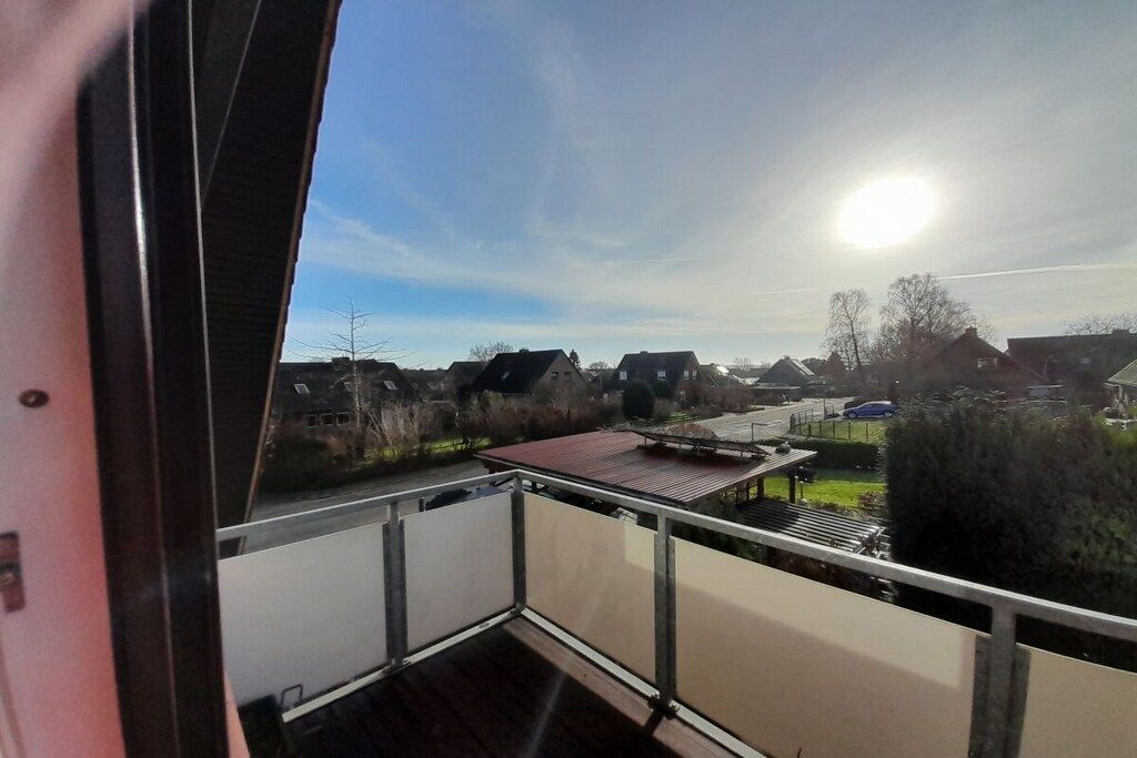 En balkong med utsikt över hus och en klar himmel.
