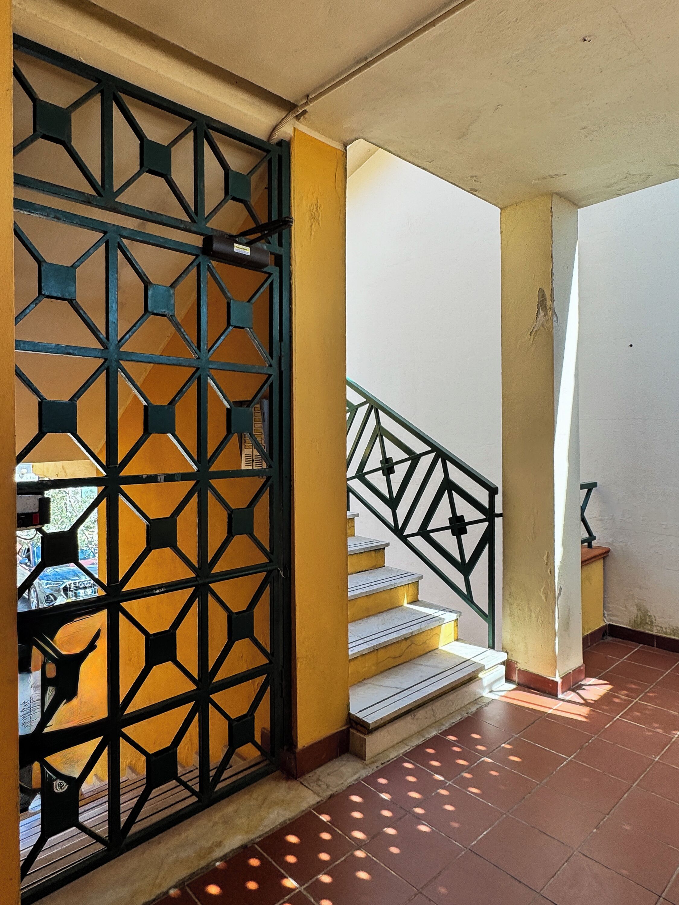 Una escalera con barandilla de metal y un separador metálico decorativo.