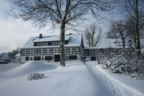 A two-story building with a snow-covered roof and a symmetrical facade. - Type B at the Gilsbach country inn (Winterberg)