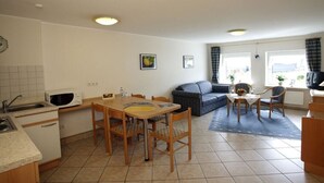 Een knus woongedeelte met kitchenette, eethoek en zithoek.