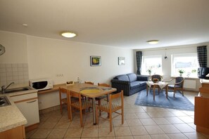 A compact living space with a kitchenette, dining area, and seating area. - Type B at the Gilsbach country inn (Winterberg)