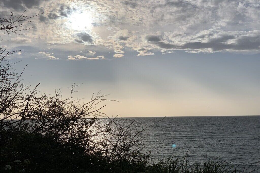 Een kustlandschap met uitzicht op zee en een heldere lucht.